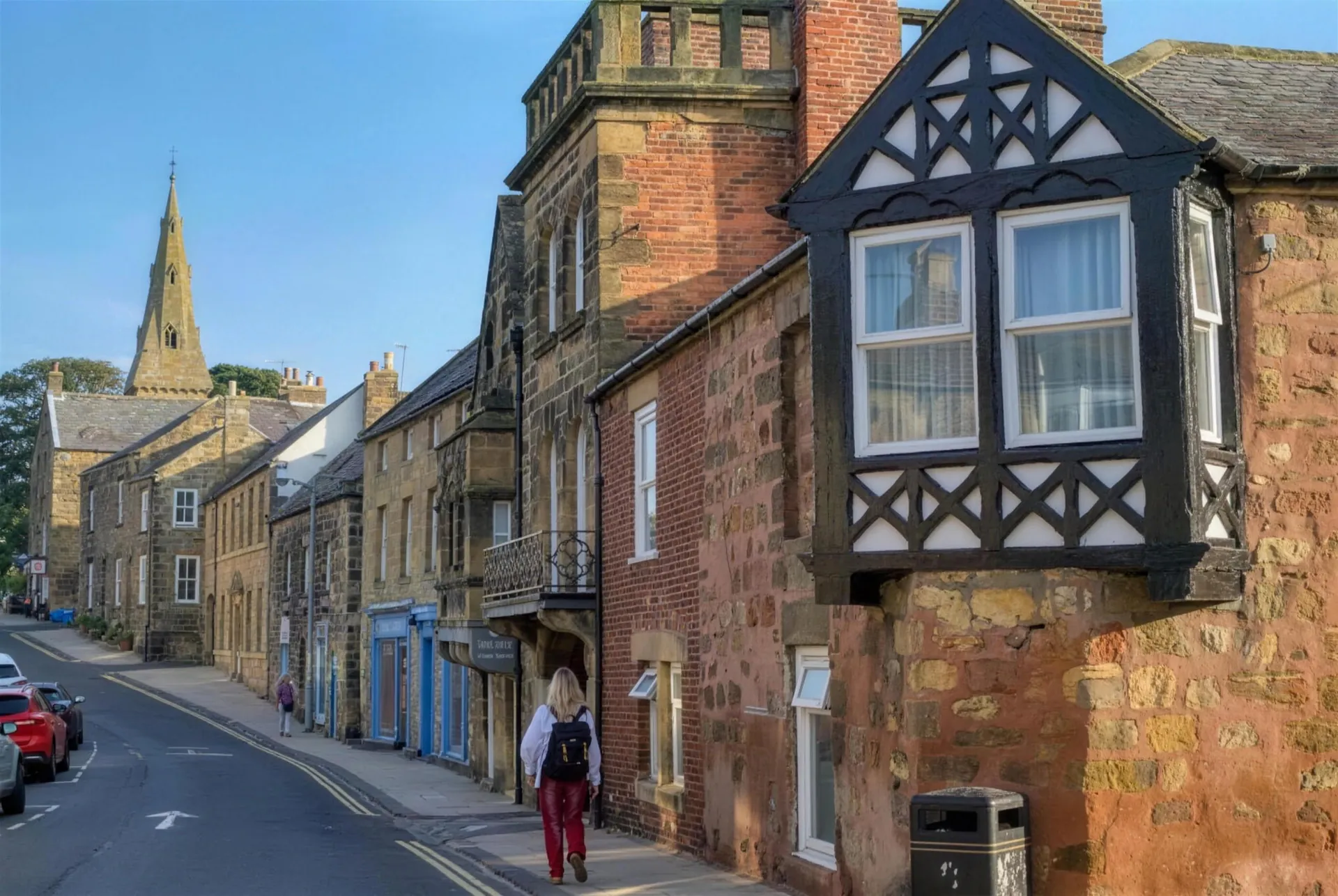 Stone houses and the church spire on a street in Alnmouth